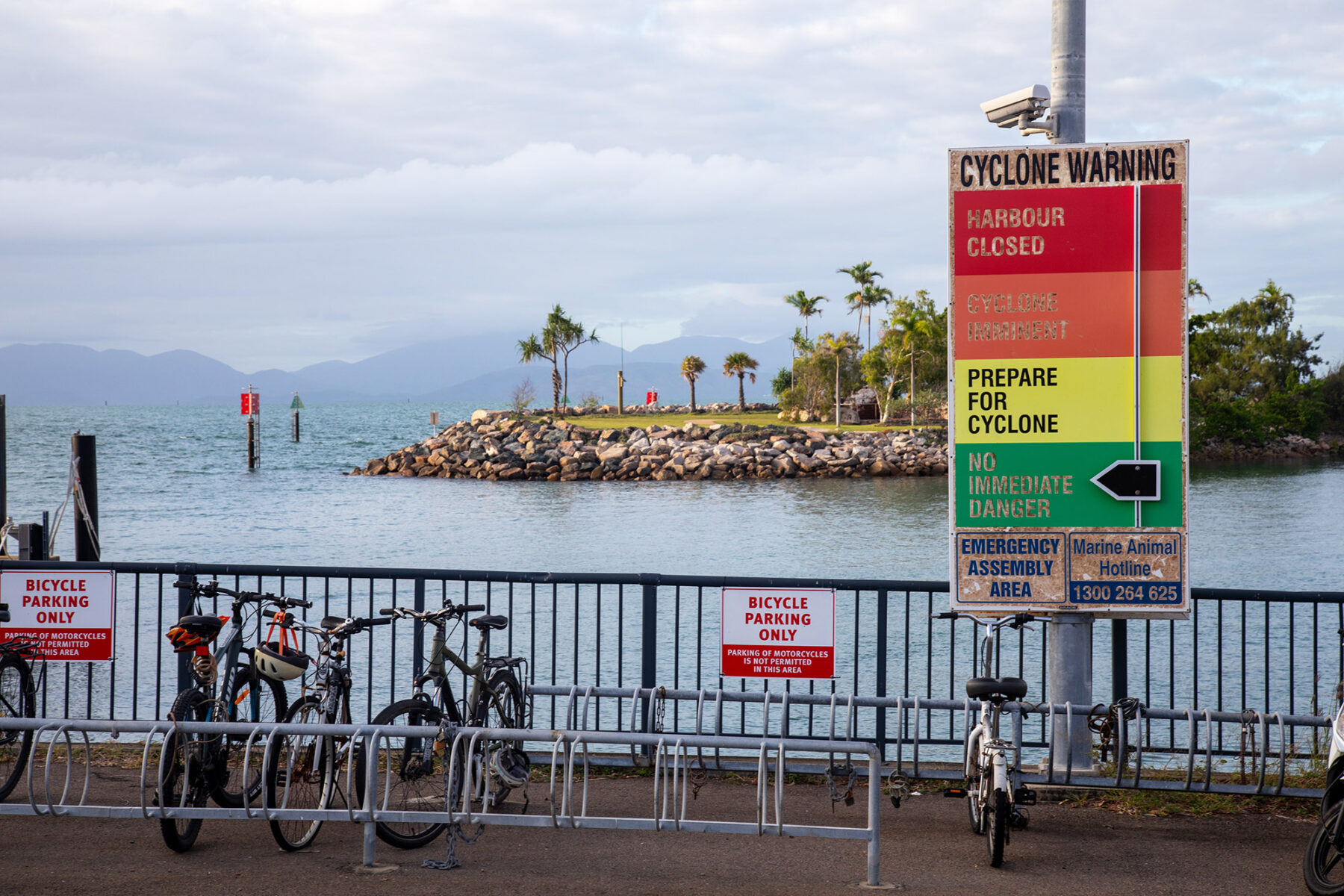 A cyclone warning sign on Magnetic Island with bikes parked next to it